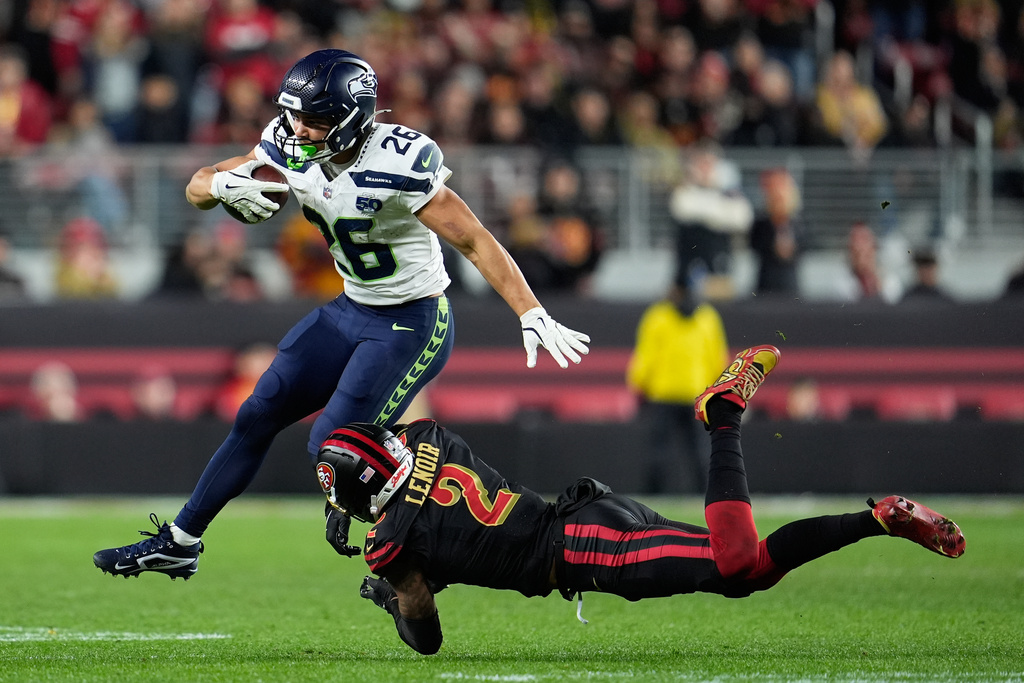 Seattle Seahawks running back Zach Charbonnet (26) runs against San Francisco 49ers cornerback Deommodore Lenoir (2) during the second half of an NFL football game in Santa Clara, Calif., Saturday, Jan. 3, 2026. (AP Photo/Godofredo A. Vásquez)