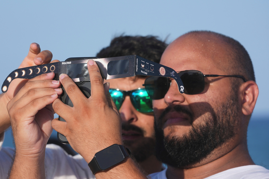 Beachgoers gather before a total solar eclipse set to begin around sunset, at Puerto de Sagunto beach near Valencia, Spain, Wednesday, Aug. 12, 2026. (AP Photo/Alberto Saiz)