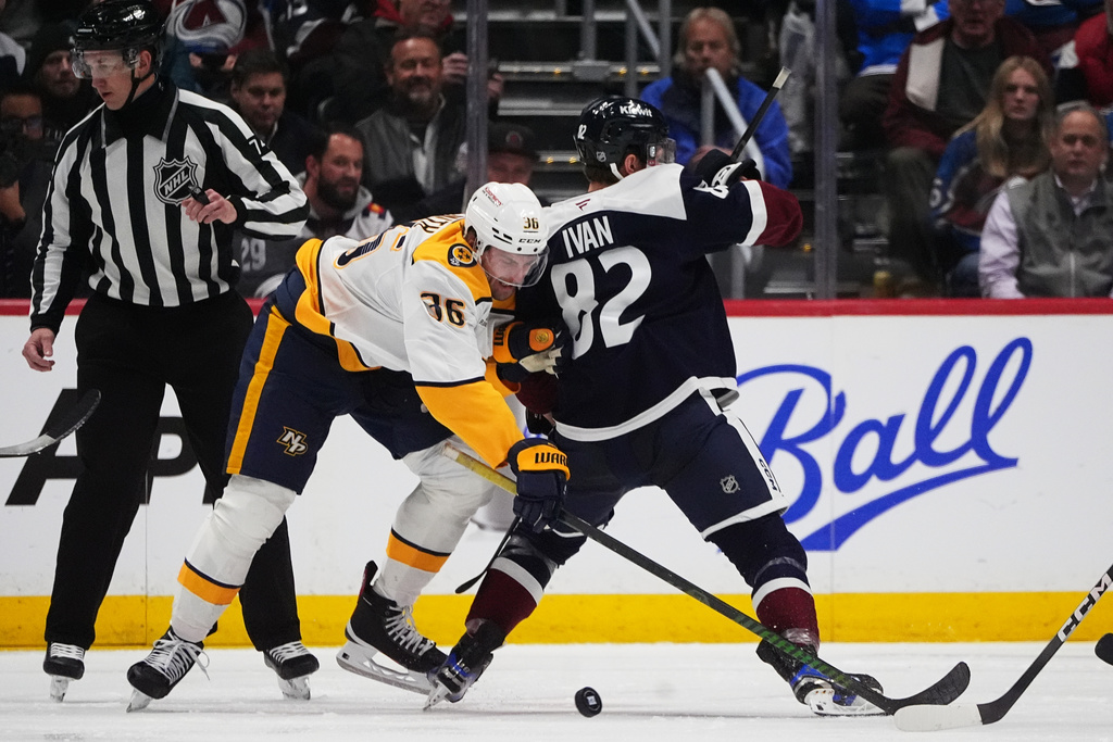 Nashville Predators left wing Cole Smith, front left, fights for control of the puck with Colorado Avalanche center Ivan Ivan, right, in the second period of an NHL hockey game Friday, Jan. 16, 2026, in Denver. (AP Photo/David Zalubowski)