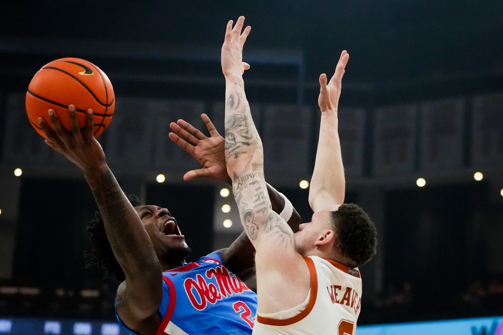Mississippi guard AJ Storr (2) shoots over Texas guard Chendall Weaver (2) during the first half of an during an NCAA college basketball game, Saturday, Feb. 7, 2026, in Austin, Texas. (Sara Diggins/Austin American-Statesman via AP)