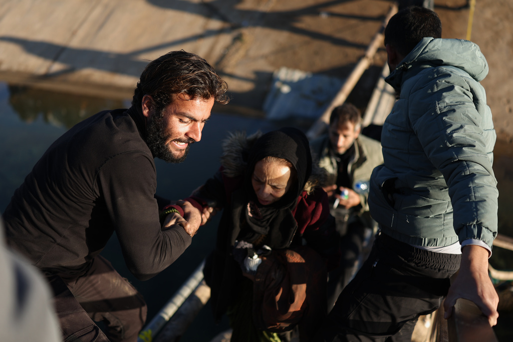 FILE - Displaced Syrians walk to cross at a river crossing near the village of Jarirat al Imam, in the eastern Aleppo countryside, near the front line with the Kurdish-led Syrian Democratic Forces in Deir Hafer, Syria, Thursday, Jan. 15, 2026. (AP Photo/Ghaith Alsayed)