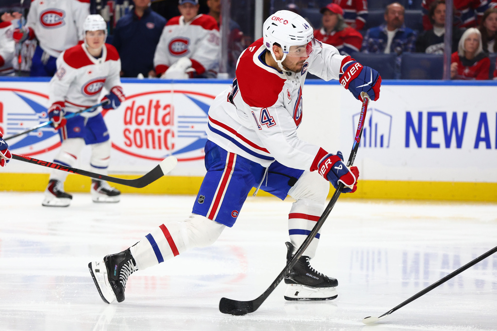 Montréal Canadiens center Nick Suzuki (14) takes a shot during the second period of an NHL hockey game against the Buffalo Sabres Saturday, Jan. 31, 2026, in Buffalo, N.Y. (AP Photo/Jeffrey T. Barnes)
