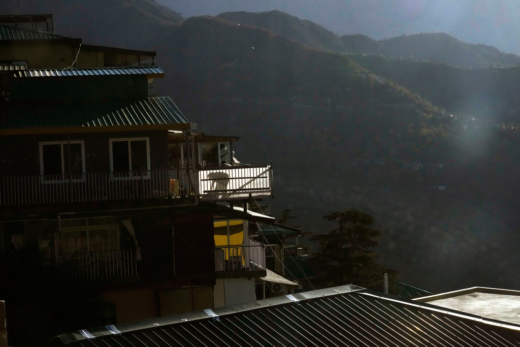 An exiled Tibetan cleans his balcony at Mcleodganj near Dharamshala, India, March 6, 2025. (AP Photo/Manish Swarup)
