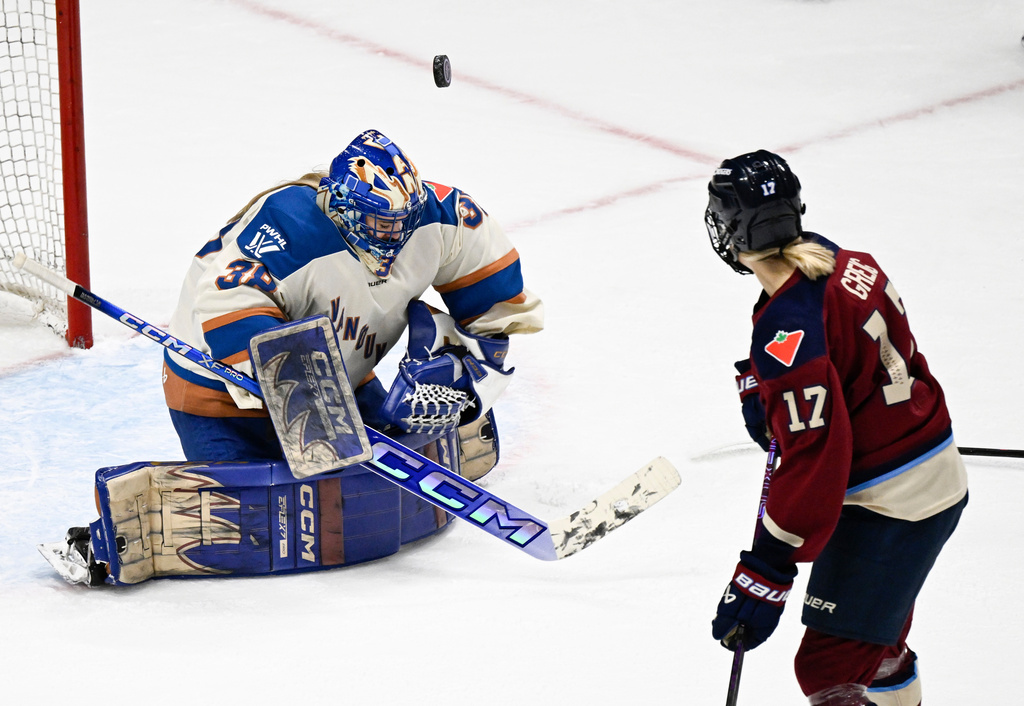 Vancouver Goldeneyes goalie Emerance Maschmeyer, left, juggles the puck as Montreal Victoire's Dara Greig, right, skates by during first-period PWHL hockey game action in Quebec City, Sunday, Jan. 11, 2026. (Jacques Boissinot/The Canadian Press via AP)