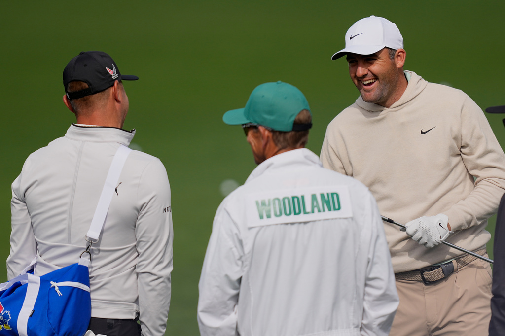 Scottie Scheffler talks with Gary Woodland one the practice tee at the Masters golf tournament at the Augusta National Golf Club, Monday, April 6, 2026, in Augusta, Ga. (AP Photo/David J. Phillip)