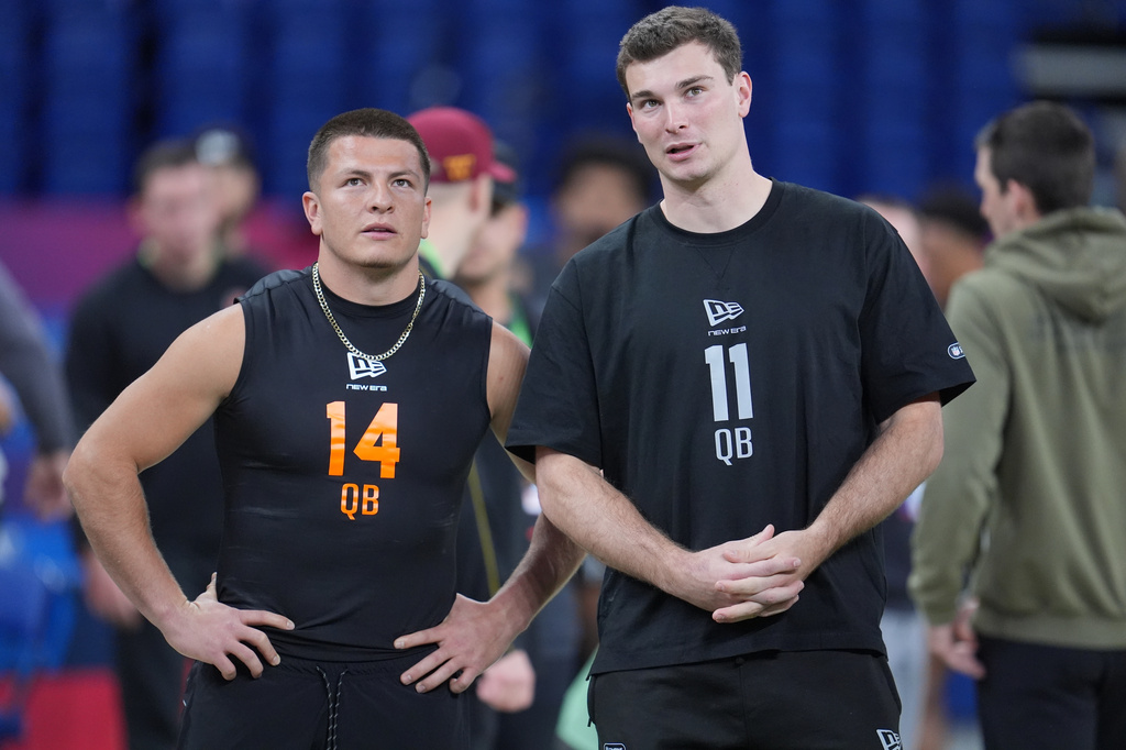 FILE - Vanderbilt quarterback Diego Pavia (14) talks to Indiana quarterback Fernando Mendoza (11) as quarterbacks run a drill at the NFL football scouting combine in Indianapolis, Saturday, Feb. 28, 2026. (AP Photo/Michael Conroy, File)
