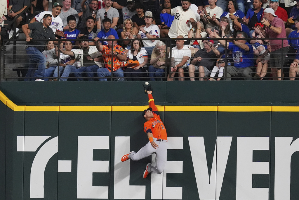 Houston Astros outfielder Cam Smith (11) can't catch the home run hit by Texas Rangers' Jake Burger during the sixth inning of a baseball game, Sunday, Sept. 7, 2025, in Arlington, Texas. (AP Photo/LM Otero)