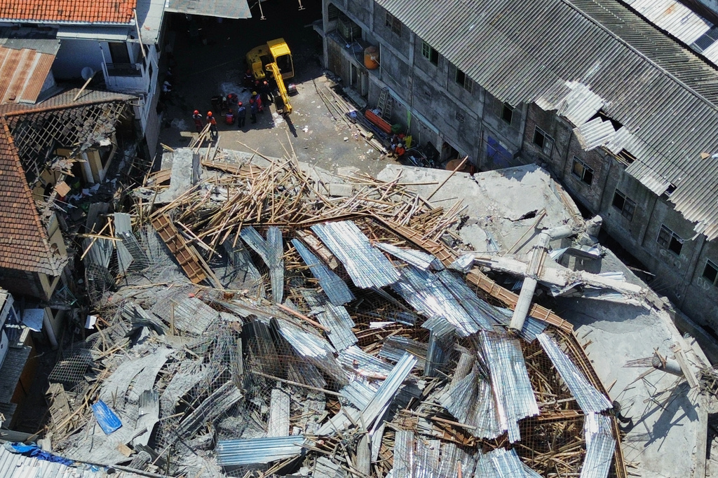 This aerial shot taken with a drone shows rescuers searching for victims trapped under the rubble after a building under construction collapsed Monday at an Islamic boarding school in Sidoarjo, East Java, Indonesia, Wednesday, Oct. 1, 2025. (AP Photo/Trisnadi)