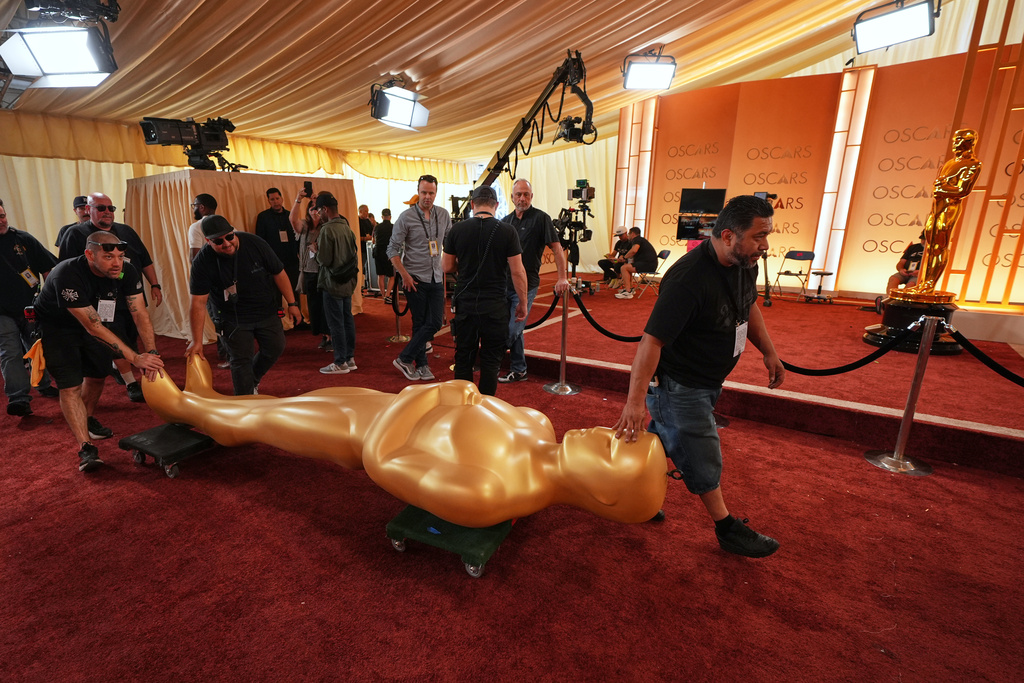 Workers install an Oscar statue at the Dolby Theatre in Los Angeles, Saturday, March 14, 2026, in preparation for Sunday's 98th Academy Awards ceremony. (AP Photo/Gregory Bull)