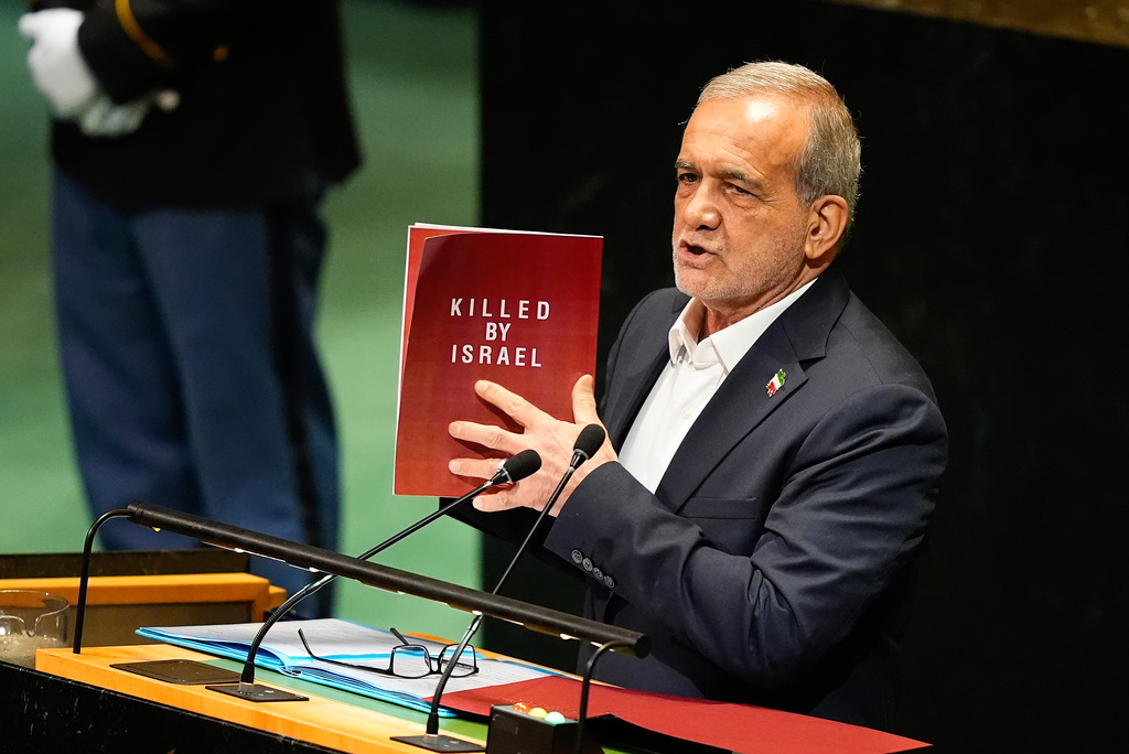 Iran President Masoud Pezeshkian holds up a book while speaking during the 80th session of the United Nations General Assembly, Wednesday, Sept. 24, 2025, at U.N. headquarters. (AP Photo/Yuki Iwamura)