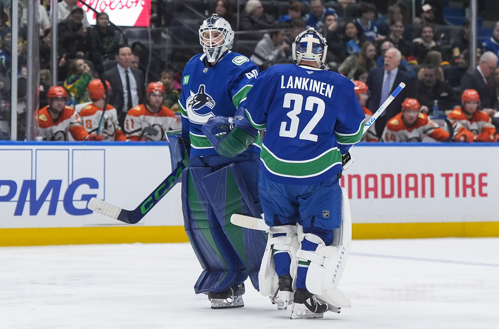 Vancouver Canucks goalie Nikita Tolopilo, left, comes back into the game after goalie Kevin Lankinen started the second period of an NHL hockey game against the Anaheim Ducks, in Vancouver, British Columbia, Thursday, Jan. 29, 2026. (Darryl Dyck/The Canadian Press via AP)