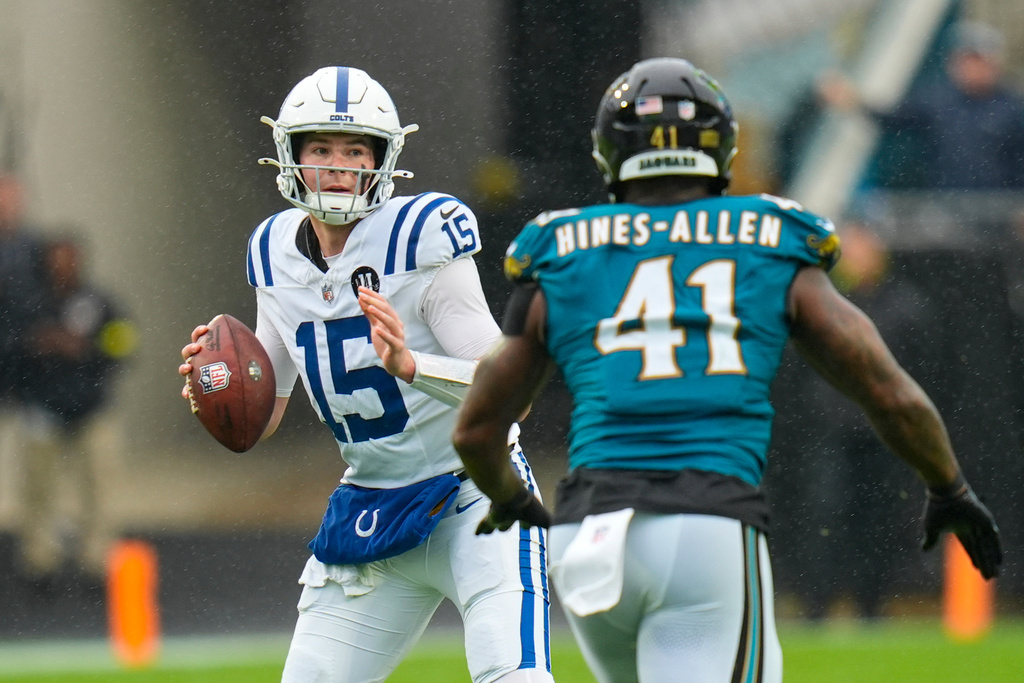 Indianapolis Colts quarterback Riley Leonard (15) looks to throw over Jacksonville Jaguars defensive end Josh Hines-Allen (41) during the first half of an NFL football game, Sunday, Dec. 7, 2025, in Jacksonville, Fla. (AP Photo/John Raoux)