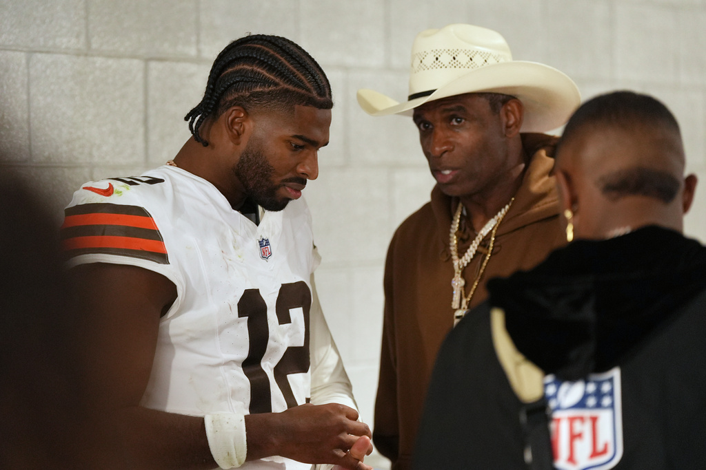 Cleveland Browns quarterback Shedeur Sanders (12) speaks with his father Deion Sanders after the Cleveland Browns defeated the Las Vegas Raiders in an NFL football game Sunday, Nov. 23, 2025, in Las Vegas. (AP Photo/Eric Gay)