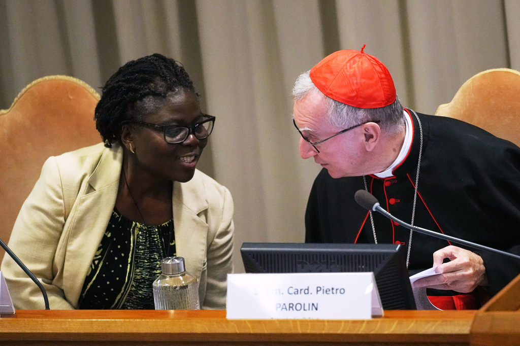 Vatican Secretary of State Cardinal Pietro Parolin, right, talks to theologian Leocadie Lushombo during the presentation of his first encyclical, "Magnifica humanitas: On Safeguarding the Human Person in the Time of Artificial Intelligence," at the Vatican, Monday, May 25, 2026. (AP Photo/Alessandra Tarantino)