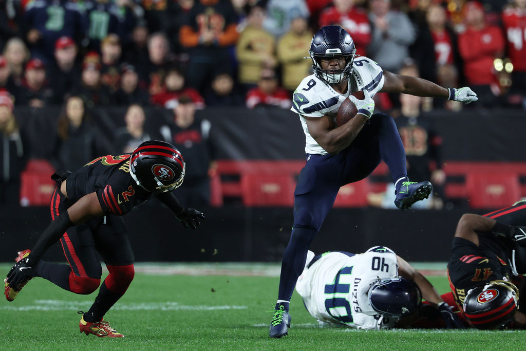 Seattle Seahawks running back Kenneth Walker III (9) runs against San Francisco 49ers cornerback Deommodore Lenoir (2) during the second half of an NFL football game in Santa Clara, Calif., Saturday, Jan. 3, 2026. (AP Photo/Jed Jacobsohn)