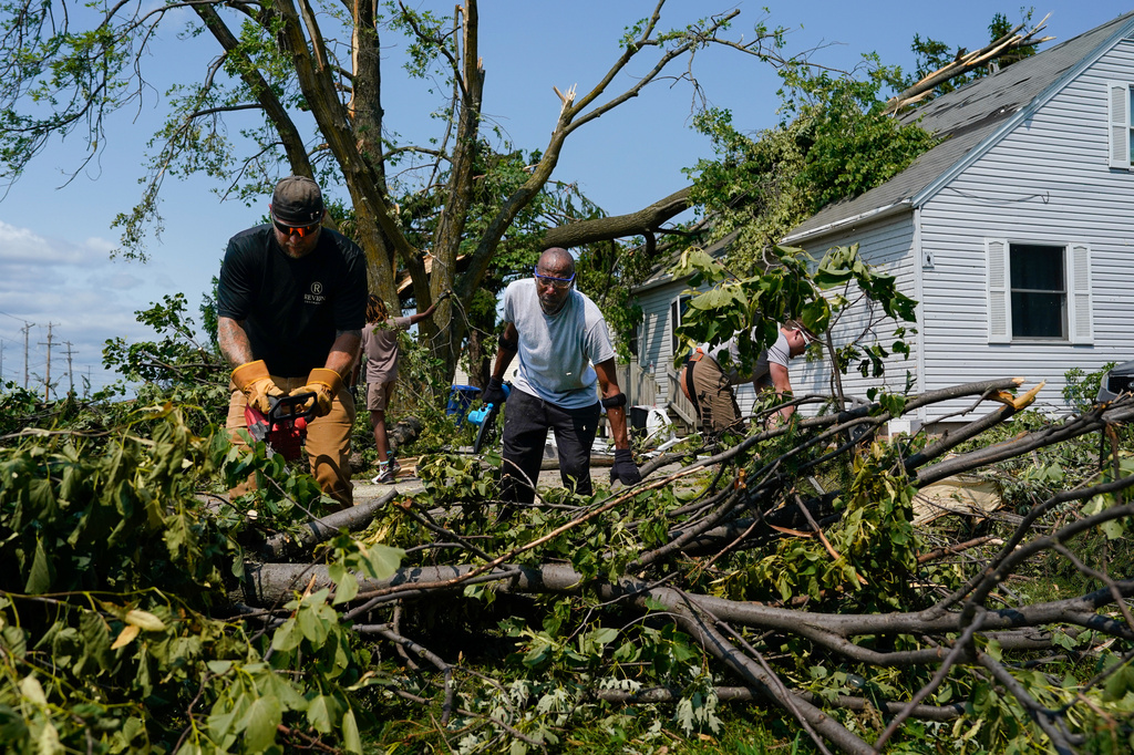 David Chew, center, clears debris at his home after a tornado hit the day before, Tuesday, July 28, 2026, in Menasha, Wis. (AP Photo/Kayla Wolf)