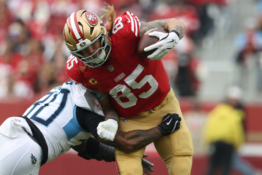 San Francisco 49ers tight end George Kittle (85) breaks a tackle by Tennessee Titans safety Kendell Brooks, left, during the first half of an NFL football game, Sunday, Dec. 14, 2025, in Santa Clara, Calif. (AP Photo/Jed Jacobsohn)