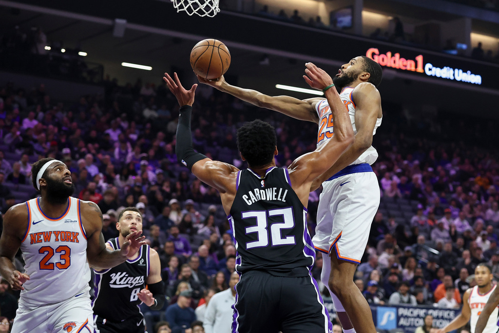 Sacramento Kings center Dylan Cardwell (32) blocks a layup by New York Knicks guard Mikal Bridges, right, during the first half of an NBA basketball game Wednesday, Jan. 14, 2026, in Sacramento, Calif. (AP Photo/Sara Nevis)