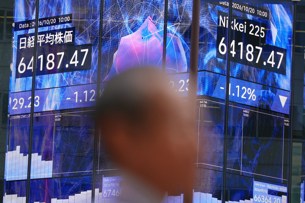 A person walks in front of an electronic stock board showing Japan's Nikkei index at a securities firm Tuesday, Oct. 20, 2026, in Tokyo. (AP Photo/Eugene Hoshiko)