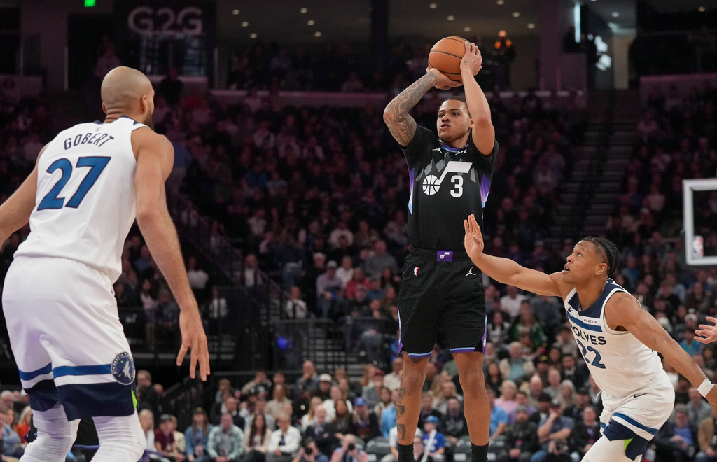 Utah Jazz guard Keyonte George (3) shoots as Minnesota Timberwolves guard Jaylen Clark (22) and center Rudy Gobert (27) defend during the first half of an NBA basketball game Tuesday, Jan. 20, 2026, in Salt Lake City. (AP Photo/Bethany Baker)