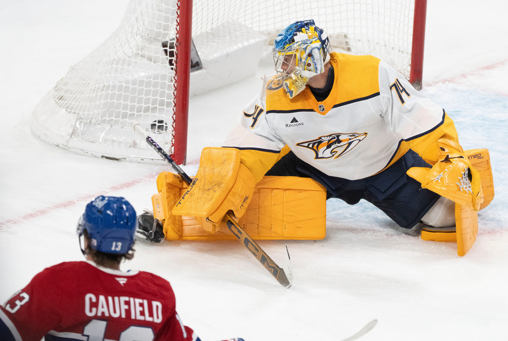 Montreal Canadiens' Cole Caufield (13) scores against Nashville Predators goaltender Juuse Saros (74) during third period NHL hockey action in Montreal on Thursday, Oct. 16, 2025. (Christinne Muschi/The Canadian Press via AP)