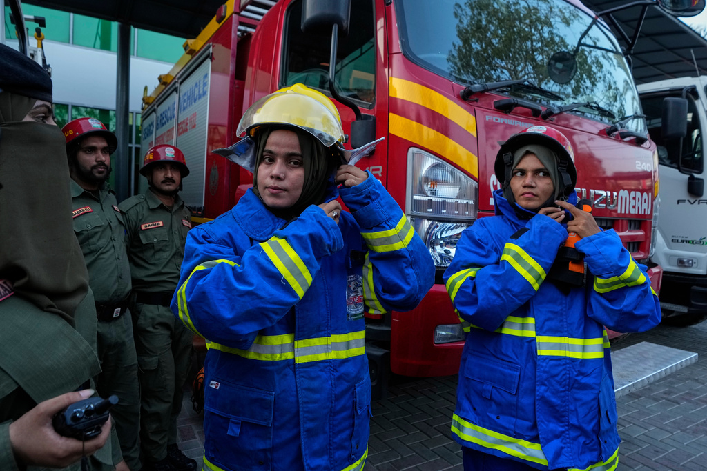 Female firefighter Syeda Masooma Zaidi, center, prepares with her team members to attend a routine training session, at the compound of their office in Karachi, Pakistan, Friday, Oct. 10, 2025. (AP Photo/Fareed Khan)