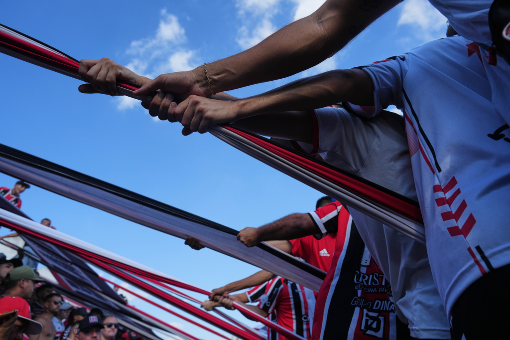 Chacarita Juniors fans hoist a flag from the stands during an Argentine soccer league match against Gimnasia y Tiro in Buenos Aires, Argentina, Sunday, April 12, 2026. (AP Photo/Rodrigo Abd)