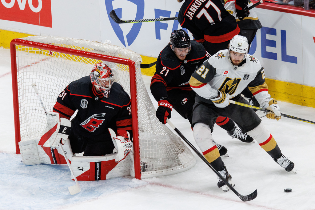 Vegas Golden Knights' Brett Howden, right, handles the puck ahead of Carolina Hurricanes' Alexander Nikishin, middle, and goaltender Frederik Andersen (31) during the second period of Game 1 of the NHL hockey Stanley Cup Final series in Raleigh, N.C., Tuesday, June 2, 2026. (AP Photo/Ben McKeown)