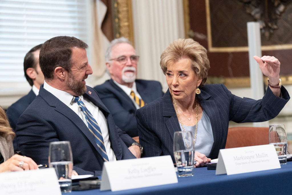 Homeland Security Secretary Markwayne Mullin and Education Secretary Linda McMahon talk during the first meeting of the Task Force to Eliminate Fraud in the Indian Treaty Room at the Eisenhower Executive Office Building on the White House complex in Washington, Friday, March 27, 2026. (AP Photo/Manuel Balce Ceneta)
