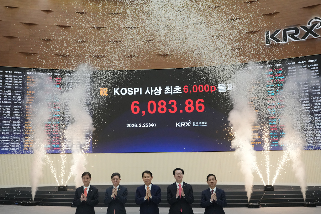 Chairman of the Financial Services Commission, Lee Eog-weon, second from left, Chairman & CEO of the Korea Exchange, Jeong Eun Bo, center, a and other officials celebrate as a screen shows the Korea Composite Stock Price Index (KOSPI) of over 6,000 points during a ceremony at the Korea Exchange in Seoul, South Korea, Wednesday, Feb. 25, 2026. (AP Photo/Lee Jin-man)