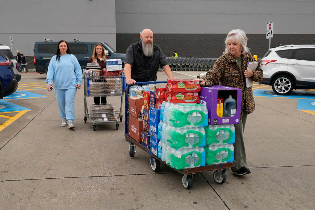 High school cafeteria worker Shirley Mease, right, is assisted by son-in-law Rick Porter, second from right, and granddaughters Kyndall Keeland, second from left, and Amarah McDonald, left, after shopping for supplies needed to make 700 free Thanksgiving meals for community members Tuesday, Nov. 25, 2025, in Springfield, Mo. (AP Photo/Jeff Roberson)