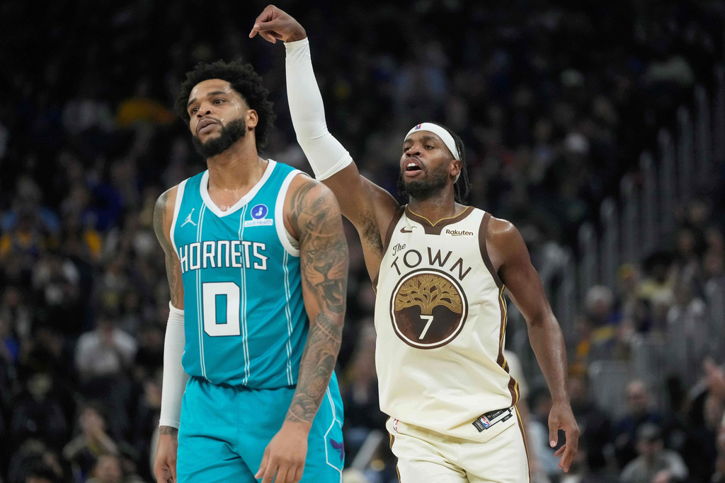 Golden State Warriors guard Buddy Hield (7) gestures after making a 3-point basket next to Charlotte Hornets forward Miles Bridges (0) during the first half of an NBA basketball game in San Francisco, Saturday, Jan. 17, 2026. (AP Photo/Jeff Chiu)