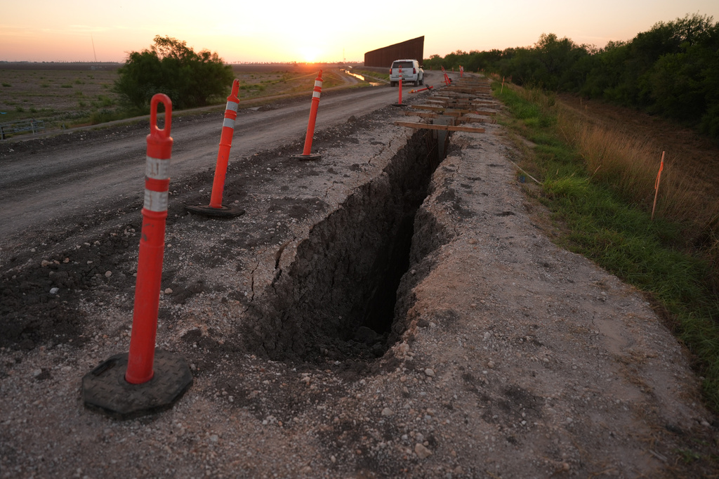 Traffic posts stand around a trench as part of the construction for a new section of border wall at the Santa Ana Wildlife Refuge in Alamo, Texas, as a U.S. Border Patrol vehicle passes through, Tuesday, Aug. 25, 2026. (AP Photo/Eric Gay)