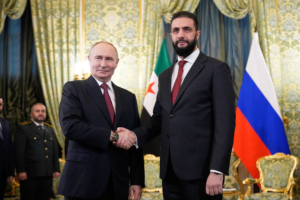 Russian President Vladimir Putin, left, and Syrian interim President Ahmad al-Sharaa shake hands during their meeting at the Grand Kremlin Palace in Moscow, Russia, Wednesday, Oct. 15, 2025. (AP Photo/Alexander Zemlianichenko, Pool)