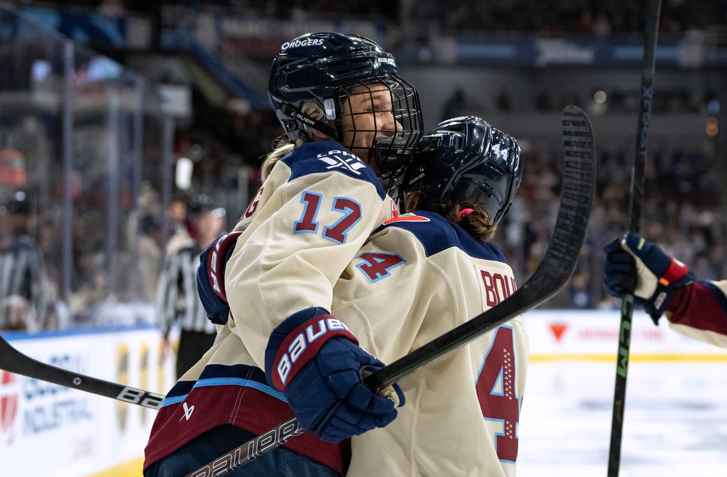 Montreal Victoire's Dara Greig (17) and Amanda Boulier celebrate Greig's goal against the Vancouver Goldeneyes during the second period of a PWHL hockey game in Vancouver, British Columbia, Saturday, Dec. 20, 2025. (Ethan Cairns/The Canadian Press via AP)