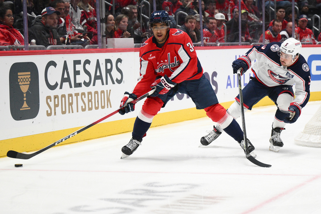 Washington Capitals right wing Justin Sourdif (34) skates with the puck past Columbus Blue Jackets defenseman Denton Mateychuk (5) during the first period of an NHL hockey game, Monday, Nov. 24, 2025, in Washington. (AP Photo/Nick Wass)