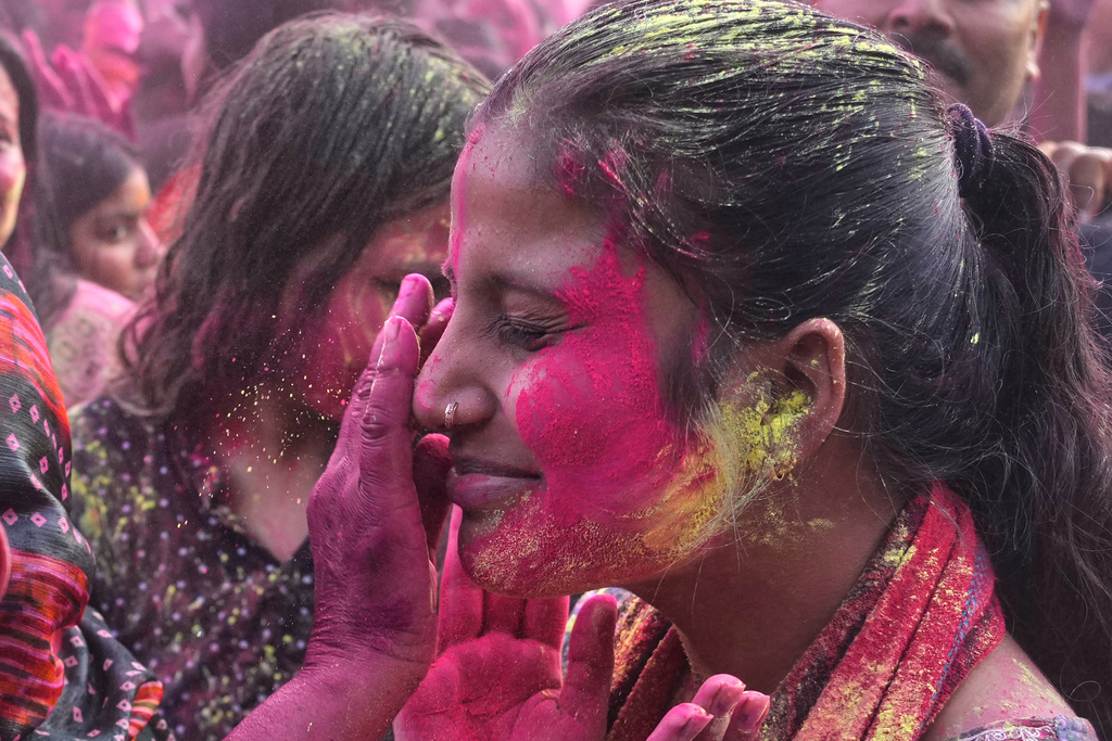 Devotees smear each other with gulal, or colored powder at the Shri Krishna Janmabhoomi Temple complex during Holi festival celebrations in Mathura, India, on Feb. 27, 2026. (AP Photo/Manish Swarup)