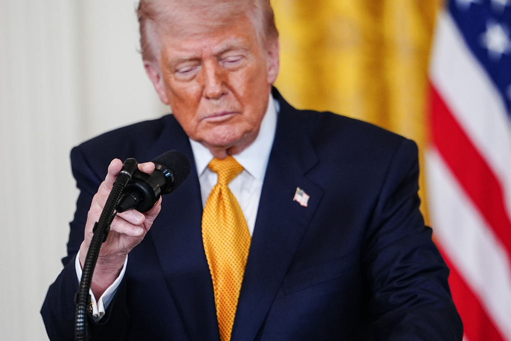 President Donald Trump adjusts his microphone while speaking during an event for military mothers in the East Room of the White House, Wednesday, May 6, 2026, in Washington. (AP Photo/Julia Demaree Nikhinson)