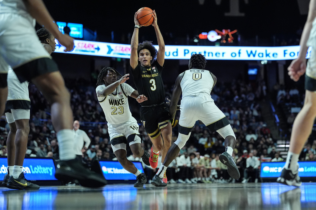 Vanderbilt guard Tyler Tanner (3) drives between Wake Forest forward Jaylen Cross (23) and forward Omaha Biliew (0) during the second half of an NCAA college basketball game, Sunday, Dec. 21, 2025, in Winston-Salem, N.C. (AP Photo/Matt Kelley)