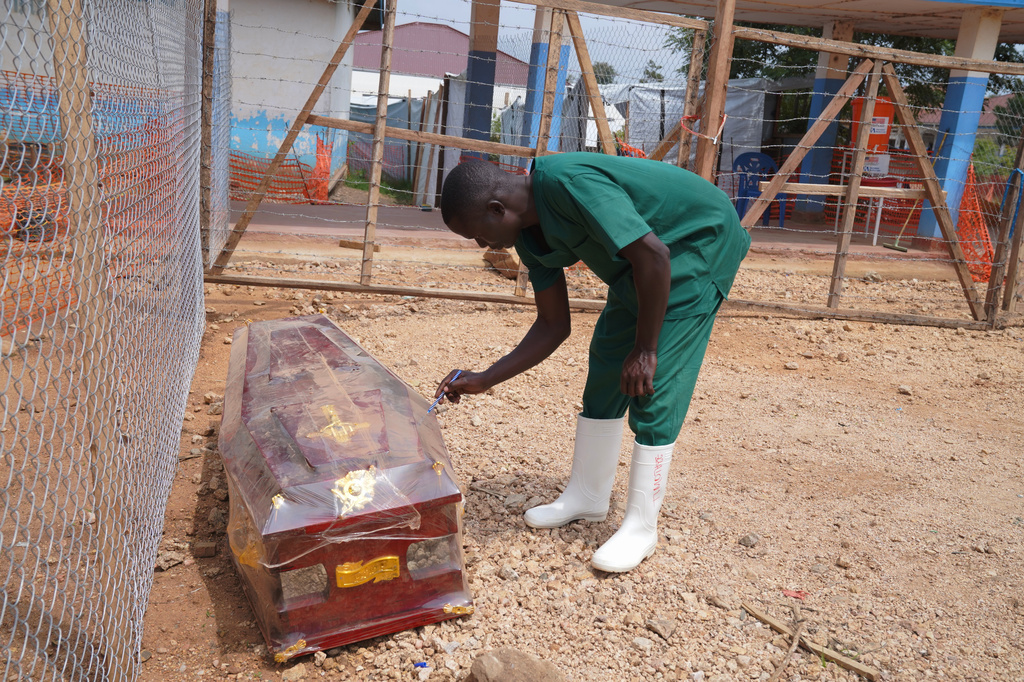 A health worker on the dignified and safe burial team, monitors a casket at the treatment centre in Bunia General Hospital in Ituri, eastern Congo, Tuesday, Aug. 11, 2026. (AP Photo/Dieudonne Dirole)