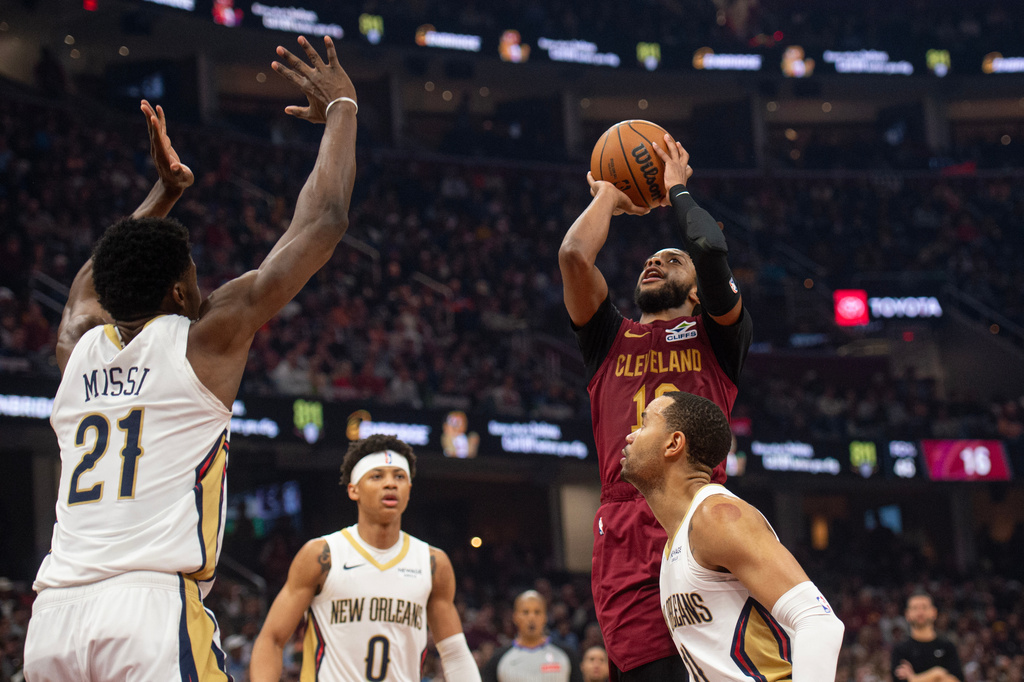 Cleveland Cavaliers' Darius Garland (10) shoots as New Orleans Pelicans' Yves Missi (21) defends and Jeremiah Fears (0) and Bryce McGowens, right, look on during the first half of an NBA basketball game in Cleveland, Tuesday, Dec. 23, 2025. (AP Photo/Phil Long)