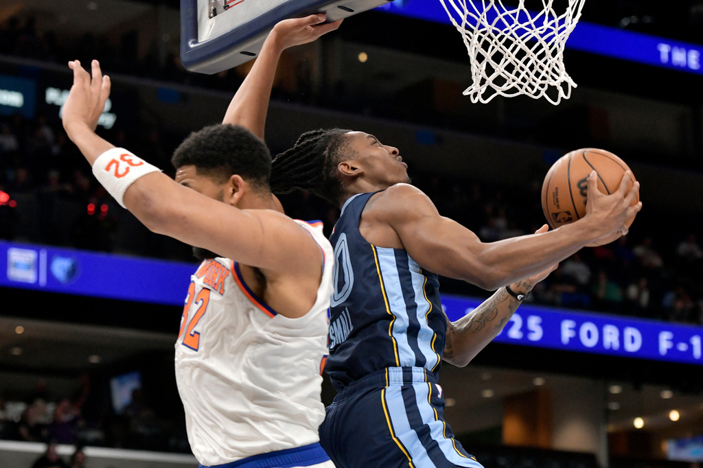 Memphis Grizzlies guard Javon Small (10) shoots against New York Knicks center Karl-Anthony Towns (32) in the first half of an NBA basketball game Wednesday, April 1, 2026, in Memphis, Tenn. (AP Photo/Brandon Dill)