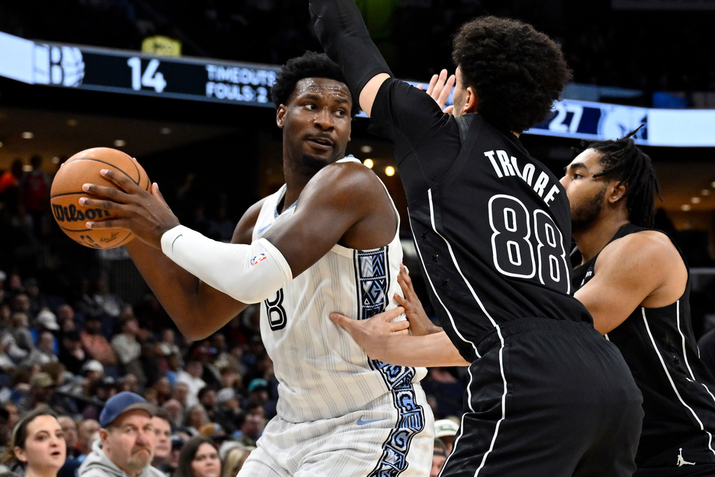 Memphis Grizzlies forward Jaren Jackson Jr. (8) handles the ball against Brooklyn Nets guards Nolan Traore (88) and Cam Thomas, right, in the first half of an NBA basketball game, Sunday, Jan. 11, 2026, in Memphis, Tenn. (AP Photo/Brandon Dill)