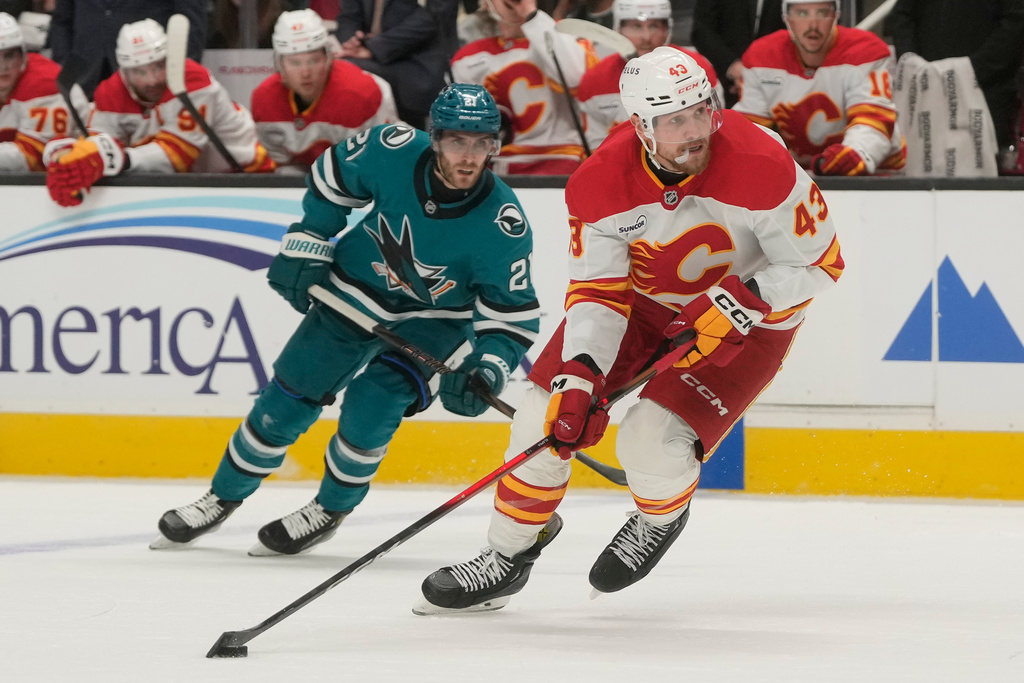Calgary Flames right wing Adam Klapka (43) skates with the puck against San Jose Sharks center Alexander Wennberg (21) during the second period of an NHL hockey game in San Jose, Calif., Thursday, Feb. 26, 2026. (AP Photo/Jeff Chiu)
