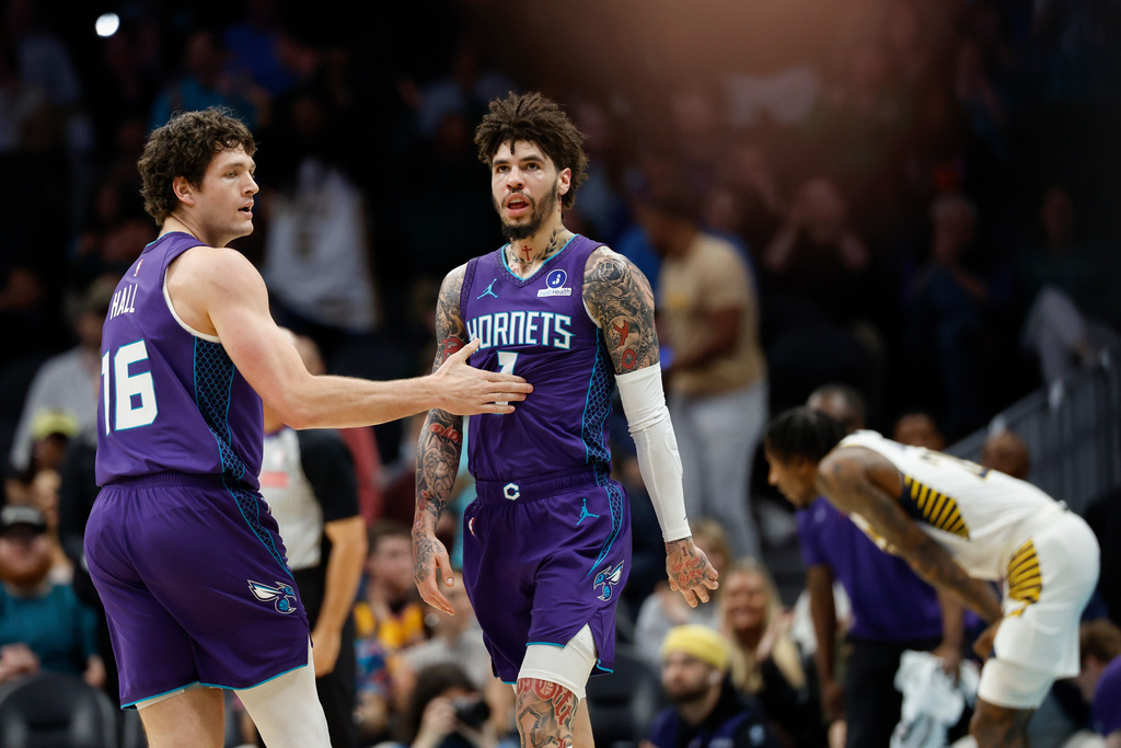 Charlotte Hornets guard LaMelo Ball (1) is congratulated by forward PJ Hall, left, after making a 3-point basket at the end of the first quarter of an NBA basketball game against the Indiana Pacers in Charlotte, N.C., Thursday, Jan. 8, 2026. (AP Photo/Nell Redmond)