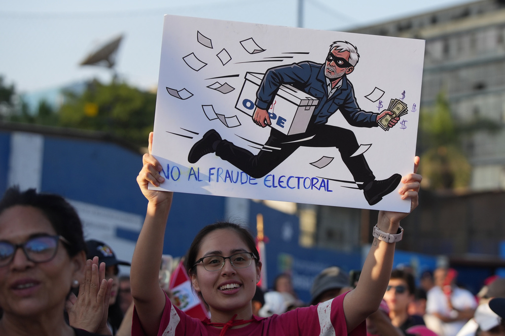 A supporter of presidential candidate Rafael Lopez Aliaga, of the Popular Renewal party, holds a sign reading in Spanish, "No to electoral fraud" during a rally in Lima, Peru, Sunday, April 19, 2026. (AP Photo/Guadalupe Pardo)