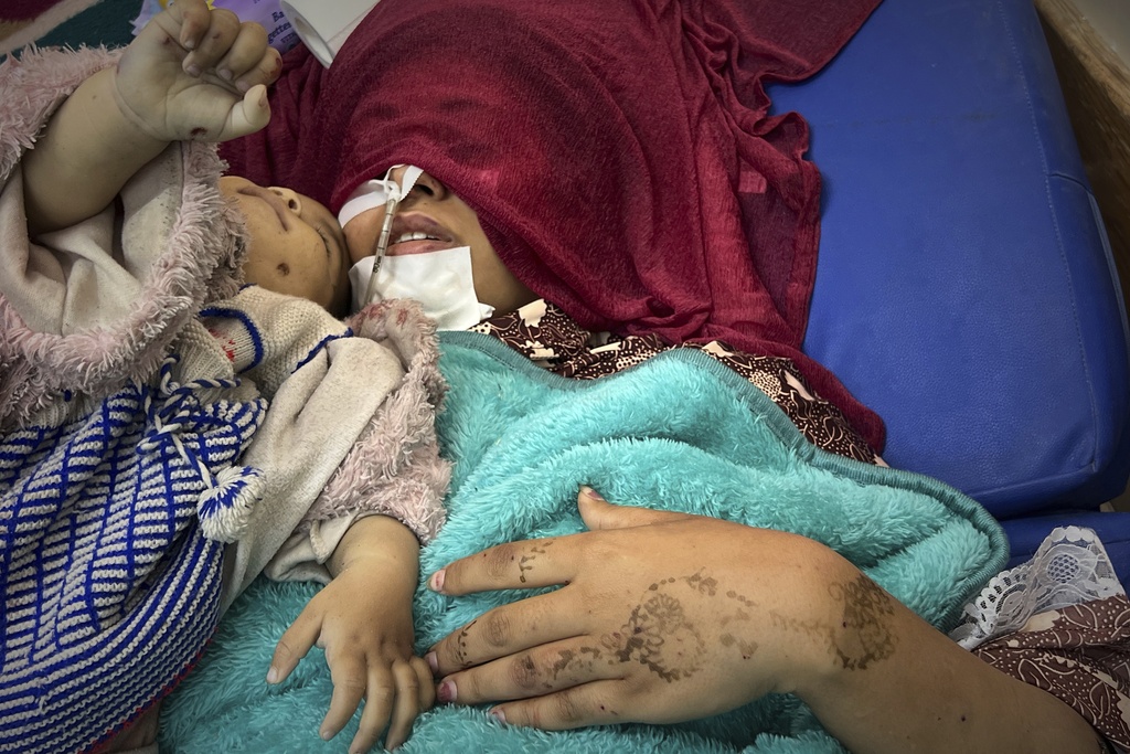 FILE - EDS NOTE: GRAPHIC CONTENT - Shaima Seiam, 23, lies wounded at Nasser Hospital beside the body of her infant daughter, Ahlam , who was days away from her first birthday, after their home was hit by an overnight Israeli airstrike, in Khan Younis, southern Gaza Strip,Wednesday, April 16, 2025. (AP Photo/Mariam Dagga, File)
