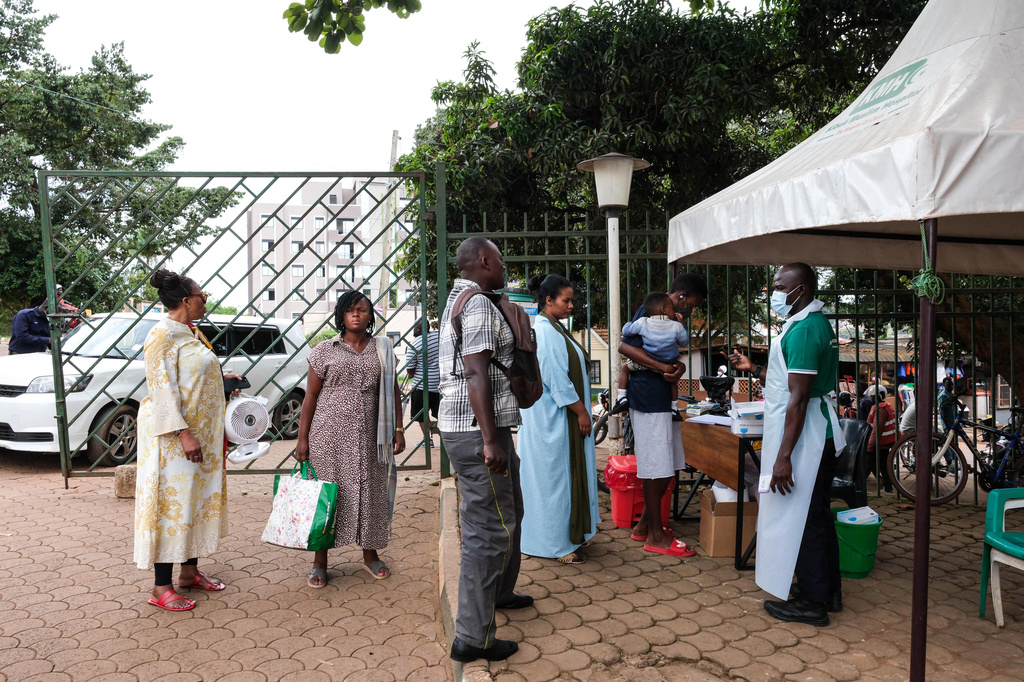 People wait to have their temperature taken in front of Kibuli Muslim Hospital in Kampala, Uganda, Saturday, May 16, 2026. (AP Photo/ Hajarah Nalwadda)