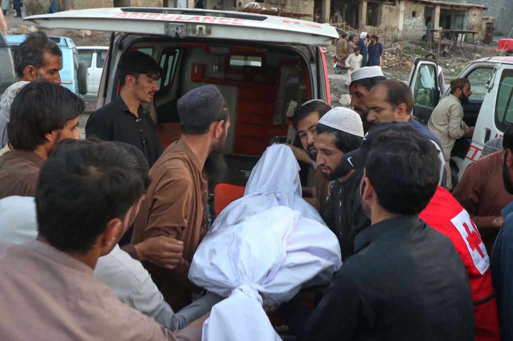 People place the body of a miner recovered after an explosion inside a coal mine, into an ambulance on the outskirts of Quetta, in southwest Pakistan, Thursday, July 30, 2026. (AP Photo/Fazal Tawab)