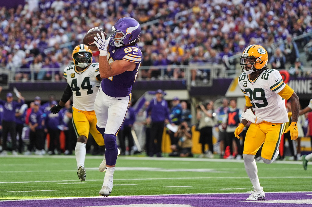 Minnesota Vikings tight end T.J. Hockenson (87) catches a touchdown pass as Green Bay Packers' Zaire Franklin (44) and Xavier McKinney (29) look on during the second half of an NFL football game, Sunday, Sept. 13, 2026, in Minneapolis, Minn. (AP Photo/Abbie Parr)